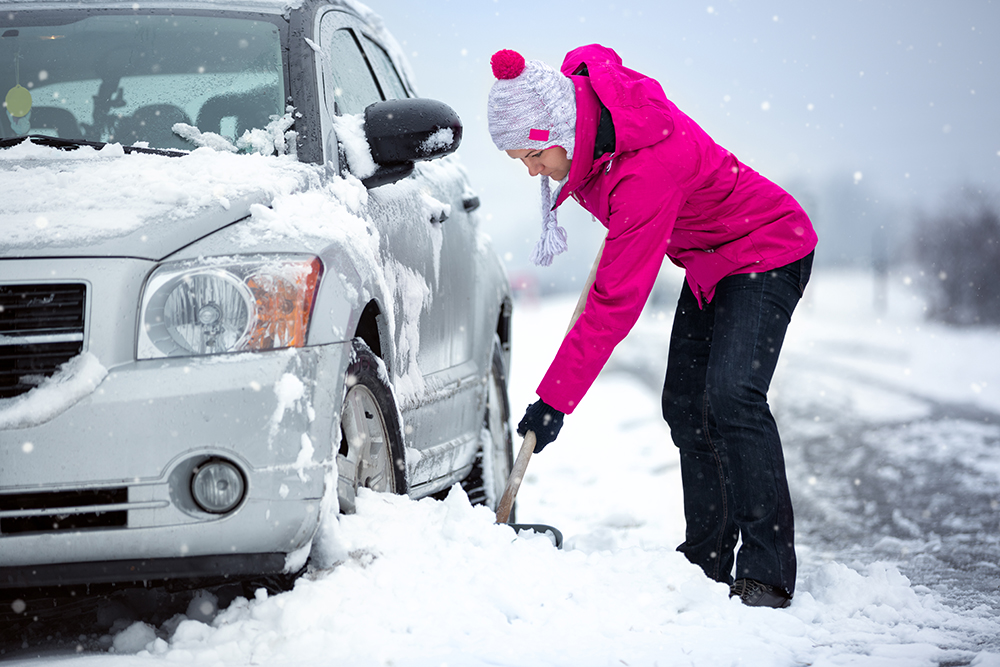 Woman Shoveling Car in Snow